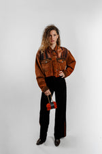 Charger l'image dans la galerie, Veste en jean vintage upcyclée caramel cuivré, portée sur un pantalon noir. Modèle court à manches longues, création La Dame de feu - Venitz Biarritz.